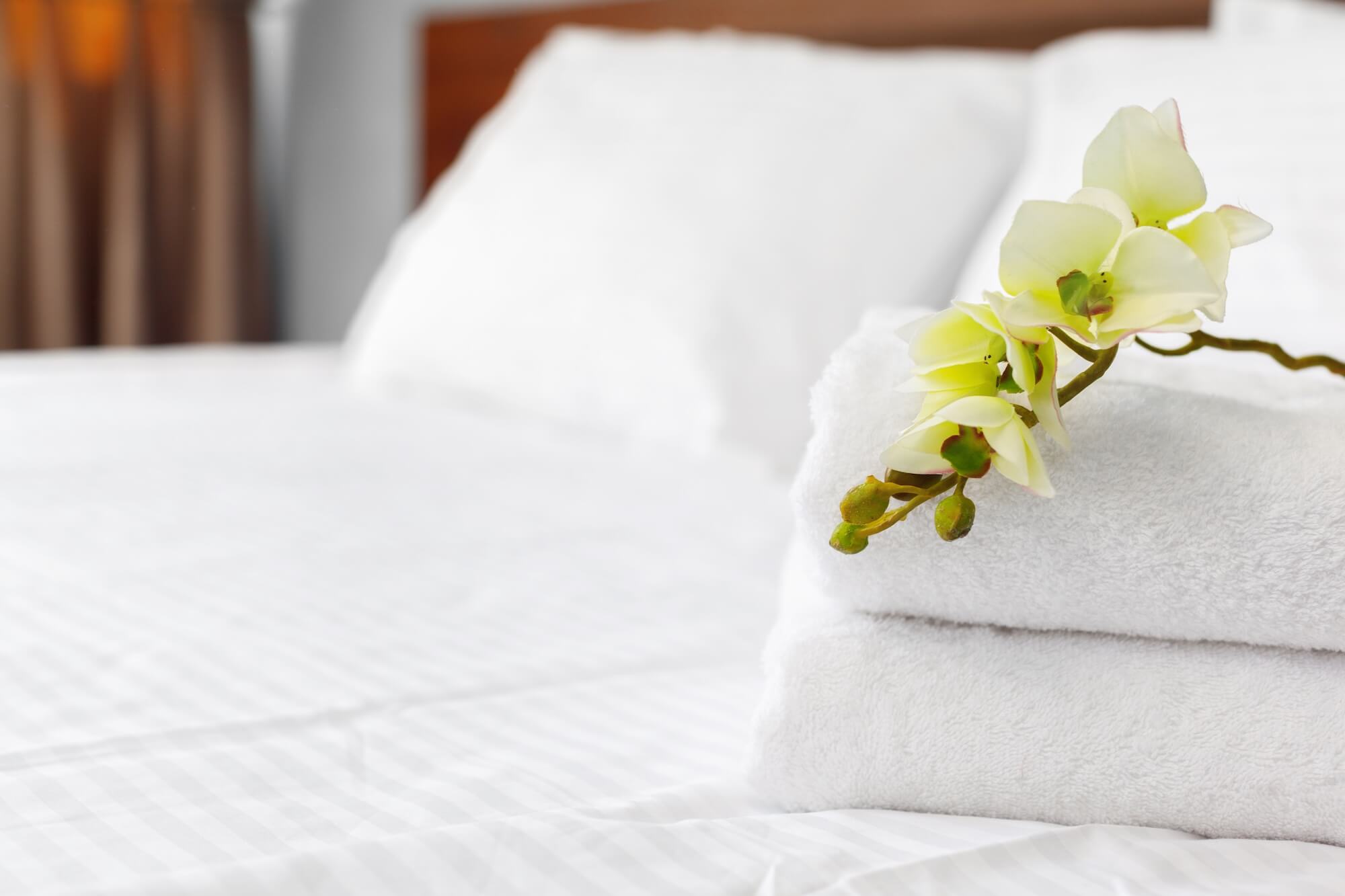 fresh towels and white orchid on a neatly made hot 2026 03 26 10 29 53 utc